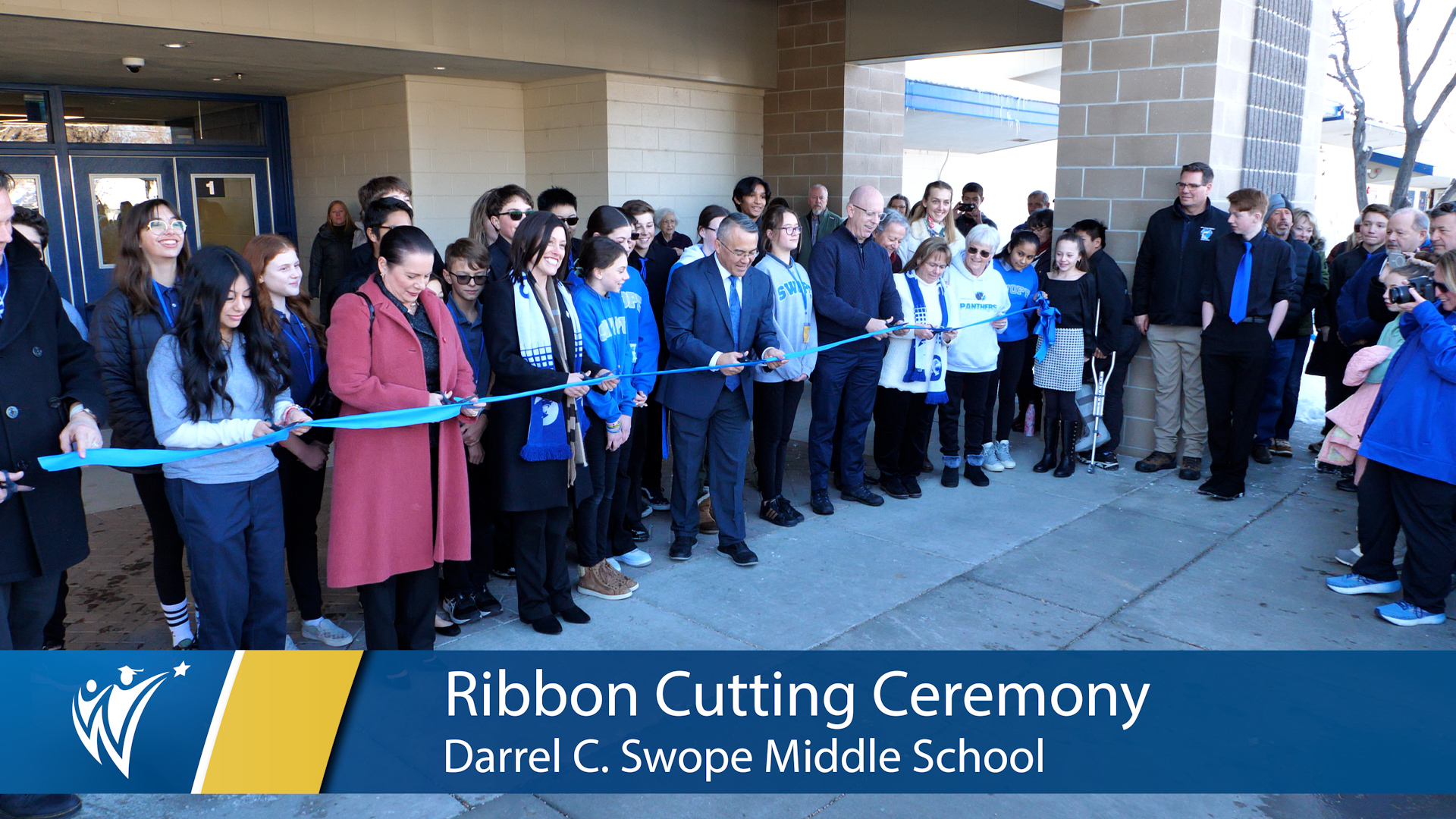  cutting the ribbon in front of the school